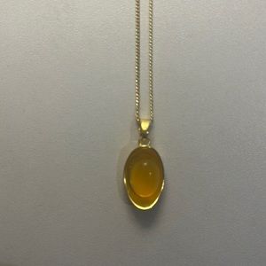 gold necklace with lucky charm yellow crystal back floral pattern